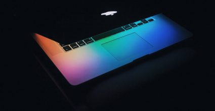 Partially opened laptop with multi color screen glow