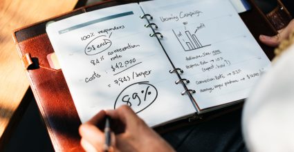 A person w iting stats in a note pad